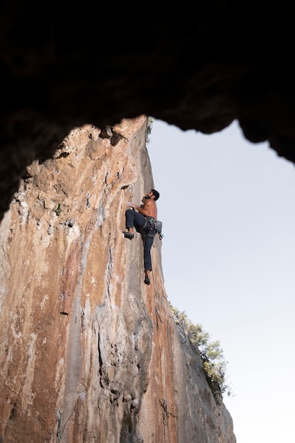 Free Photo man climbing on a mountain with safety equipment