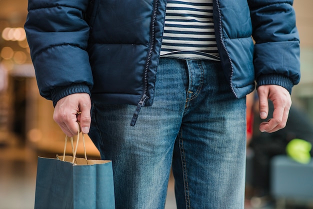 Free Photo man in coat standing holding bag