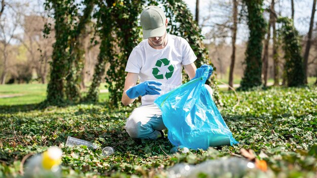 Man collecting plastic garbage in a polluted park