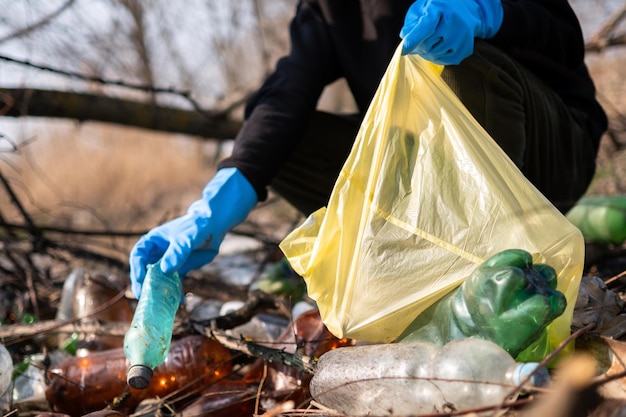 Man collecting scattered plastic bottles from the ground