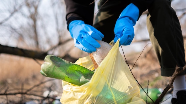 Man collecting scattered plastic bottles from the ground