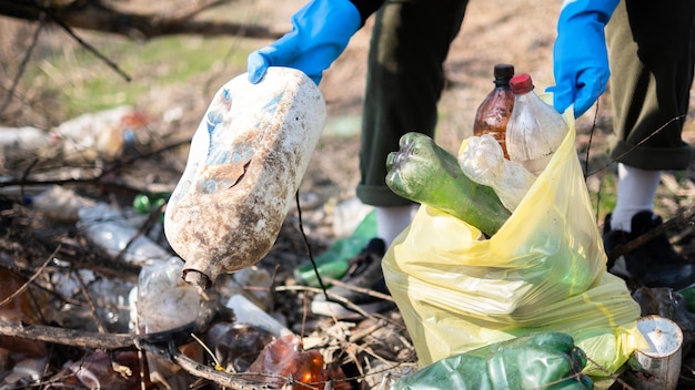 Man collecting scattered plastic bottles from the ground