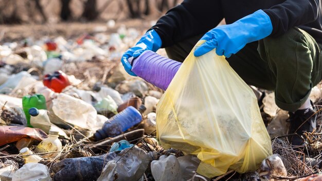 Man collecting scattered plastic bottles from the ground