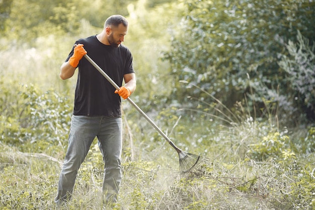 Man collects leaves and cleans the park