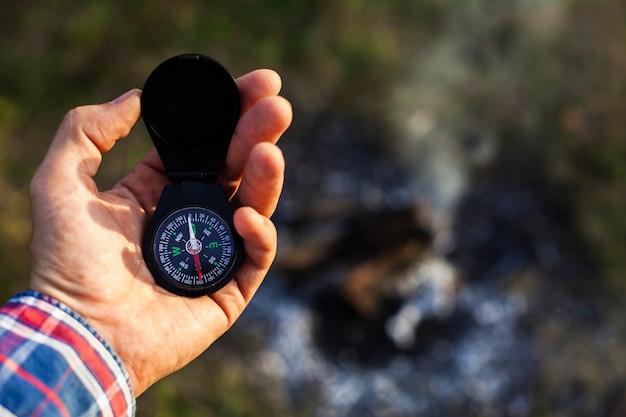 Free photo man consulting compass while camping