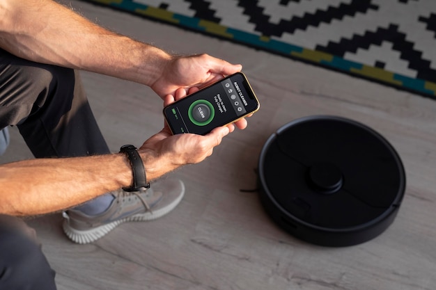 Free Photo man controlling a robot vacuum with his phone