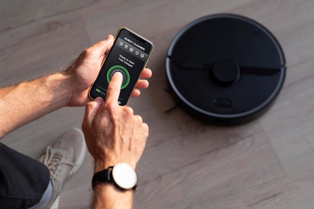 Free Photo man controlling a robot vacuum with his phone