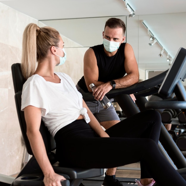 Free photo man conversing with woman at the gym while wearing medical mask