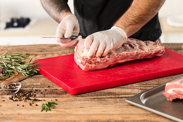 Free Photo man cooking meat steak on kitchen