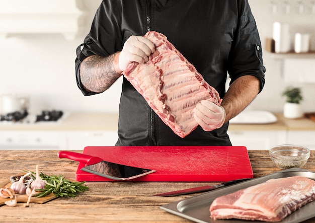 Free photo man cooking meat steak on kitchen