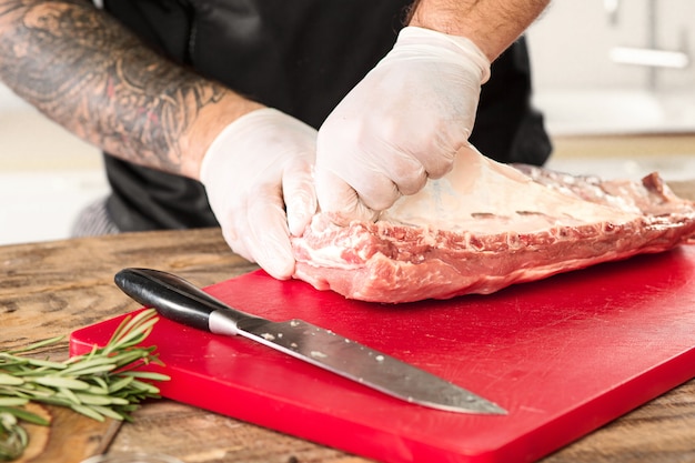 Free Photo man cooking meat steak on kitchen