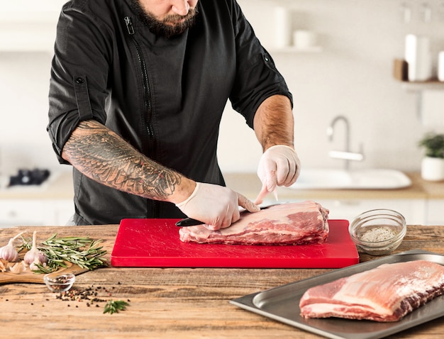 Free photo man cooking meat steak on kitchen