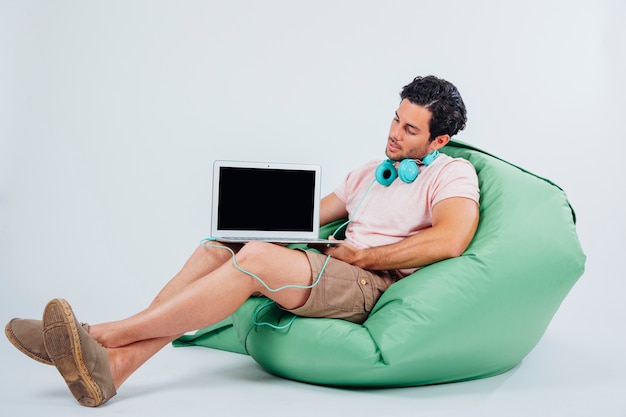 Man on couch presenting laptop