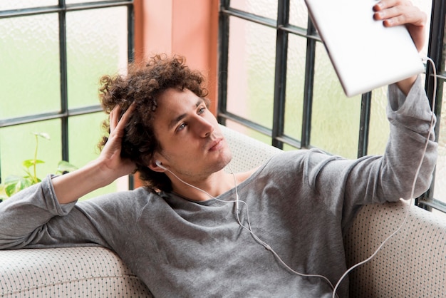 Free Photo man on couch wearing headphones