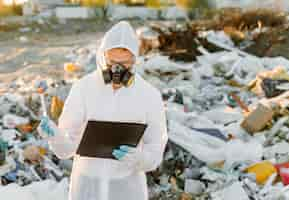 Free photo man in coveralls at trash pill. doing research. concept of ecology, environmental pollution.