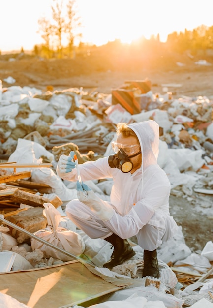 Man in coveralls at trash pill, doing research