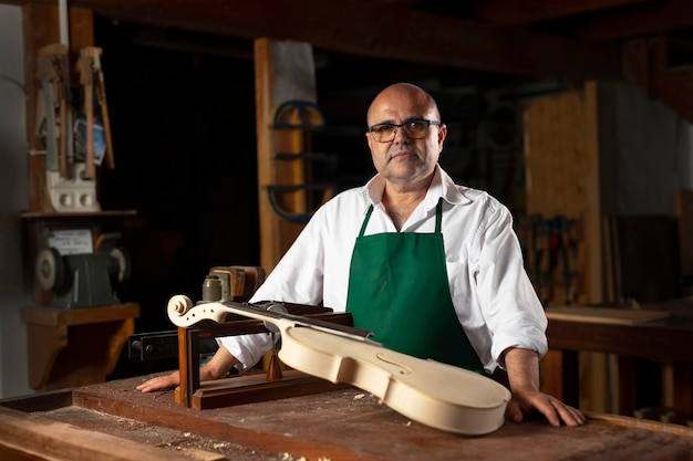 Free photo man crafting an instrument in his workshop