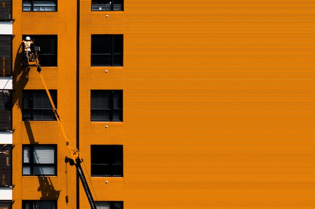 Man on crane cleaning windows