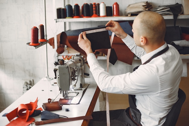 Free photo man  creates leather ware