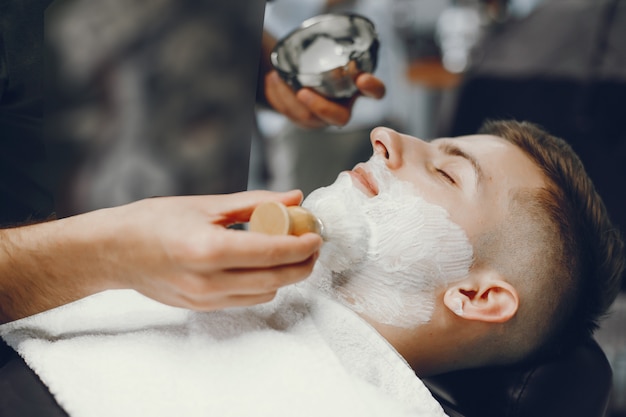 The man cuts his beard in the barbershop