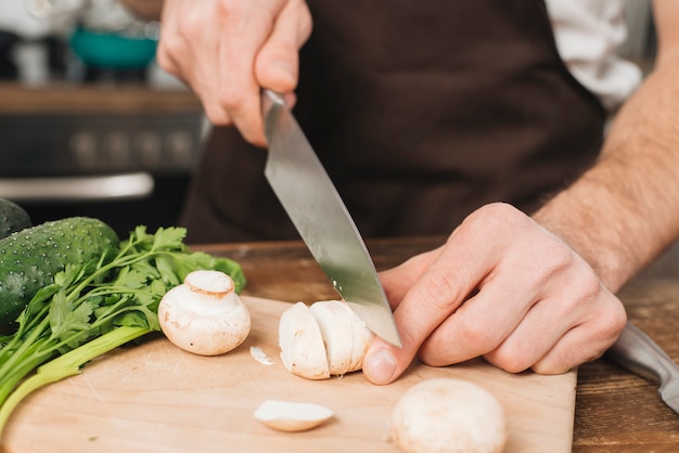 Free photo man cutting mushrooms