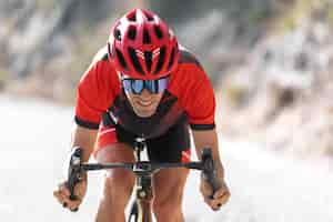 Free photo man cycling outdoors with his bike and helmet