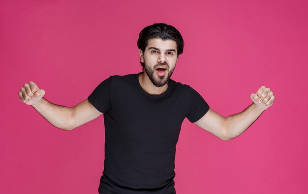 Man demonstrating his fists and muscles and showing that he is powerful and lucky