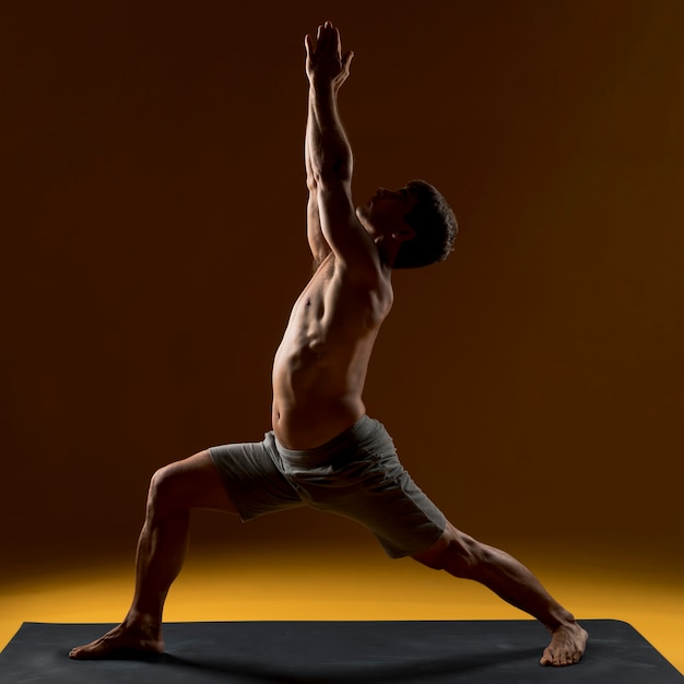 Free photo man doing exercise on yoga mat