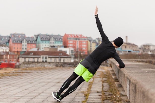 Free photo man doing exercises in city