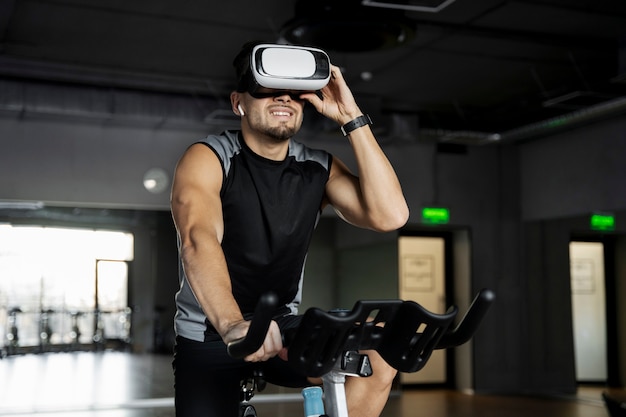 Man doing indoor cycling wit vr glasses