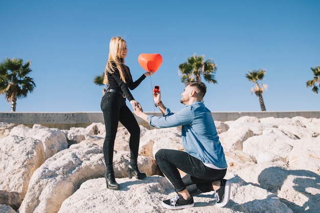 Free photo man doing proposal to girlfriend on shore