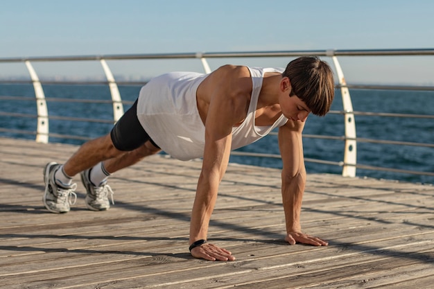 Man doing push-ups by the beach