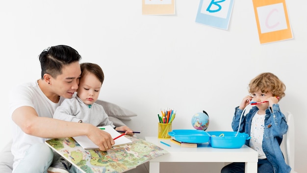 Man drawing with children at home