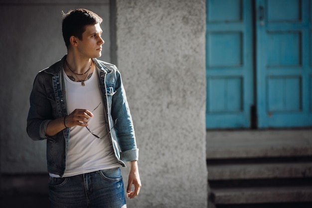 Man dressed in casual style walks outside 