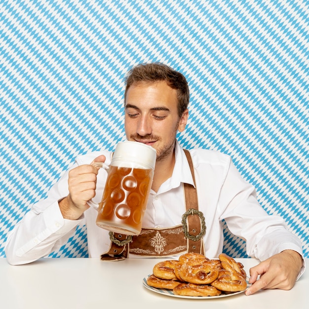 Free photo man drinking blonde beer with patterned background