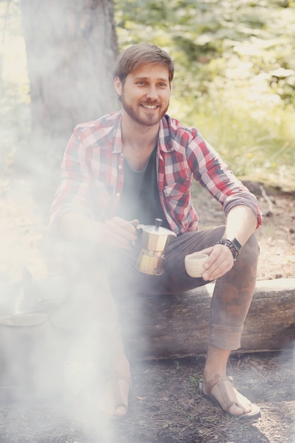 Free photo man drinking coffee in forest