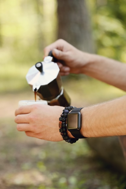 man drinking coffee in forest