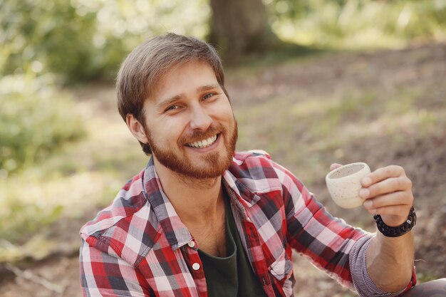 man drinking coffee in forest