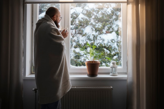 Man drinking hot beverage during energy crisis