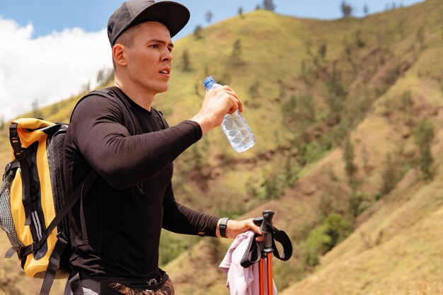 Man drinking water trekking in the mountains. bali