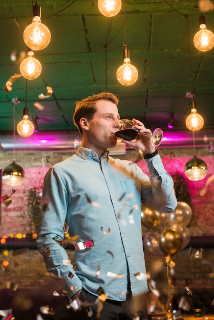 Free photo man drinking wine in party celebration at bar