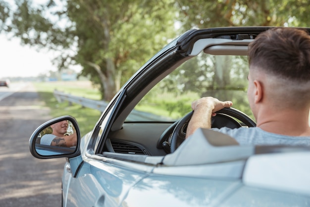 Free photo man driving a car in nature