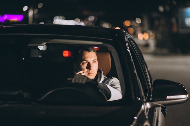 Free photo man driving a car on the road and talking on the phone