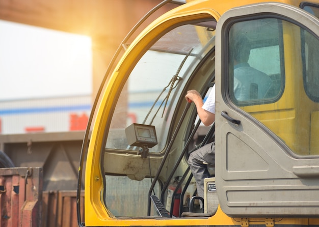 Free photo man driving a crane to lift-up some equipments