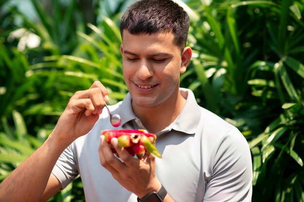 Man eating dragon fruit outdoors