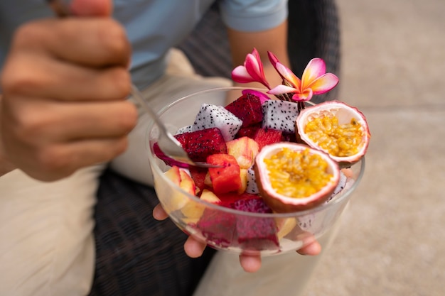 Free photo man eating dragon fruit outdoors