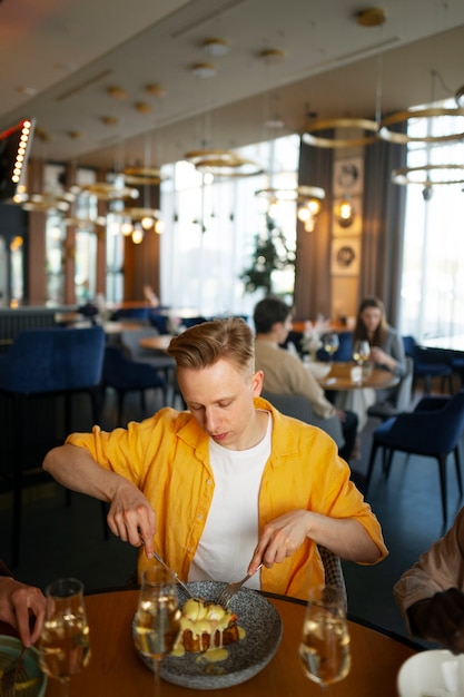 Free Photo man eating food at restaurant