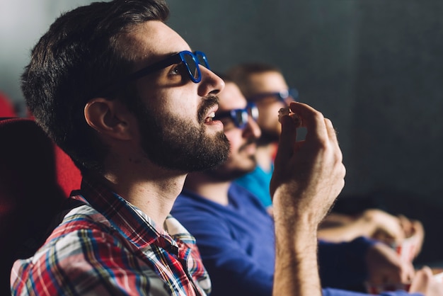 Free Photo man eating popcorn during cinema show