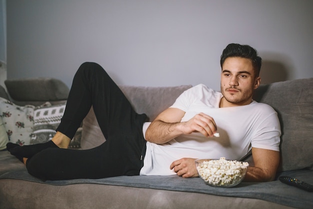 Man eating popcorn and watching TV