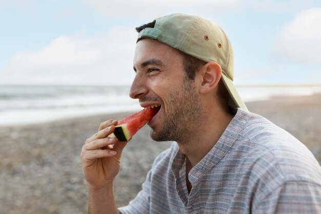 Man eating watermelon at the beach